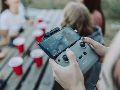 Person playing a mobile game with a controller attached to a smartphone.